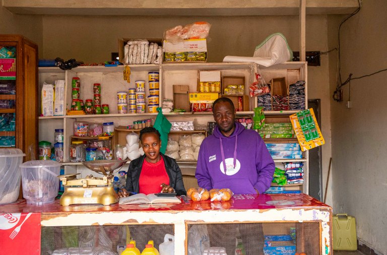 Two shop owners behind the counter of their store